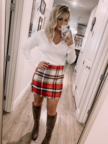 A different reviewer wearing the skirt in red, white, and black plaid