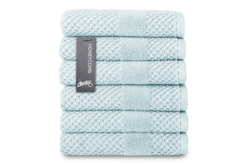 A stack of six blue hand towels folded neatly 