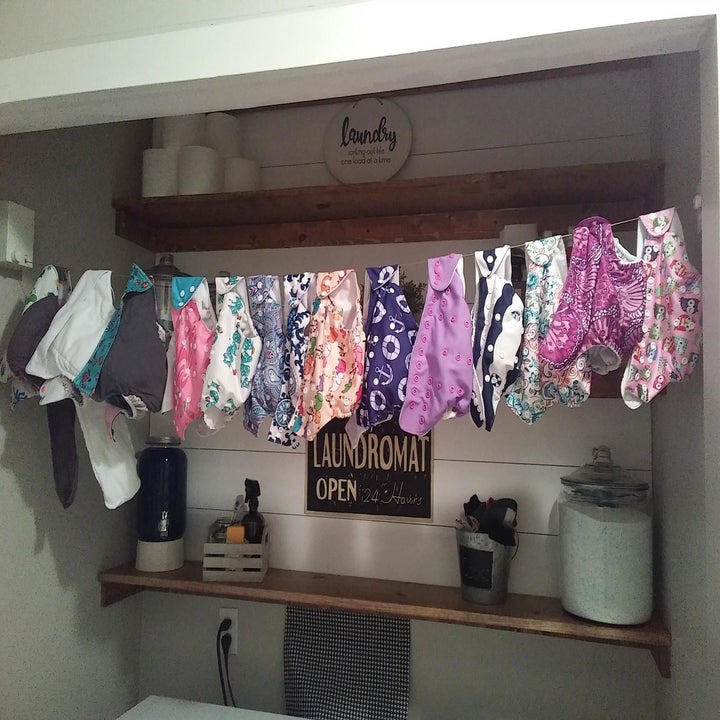A reviewer photo of multiple cloth diapers handing on the retractable indoor clothesline 