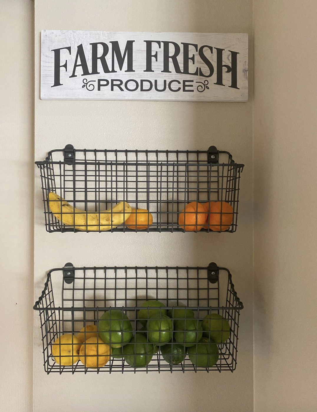 reviewer image of two baskets attached to the wall with limes and lemons and a sign above that says "farm fresh produce"