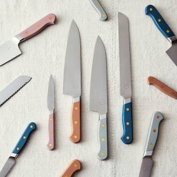 A handful of the chef, serrated, and paring knives with colored handles