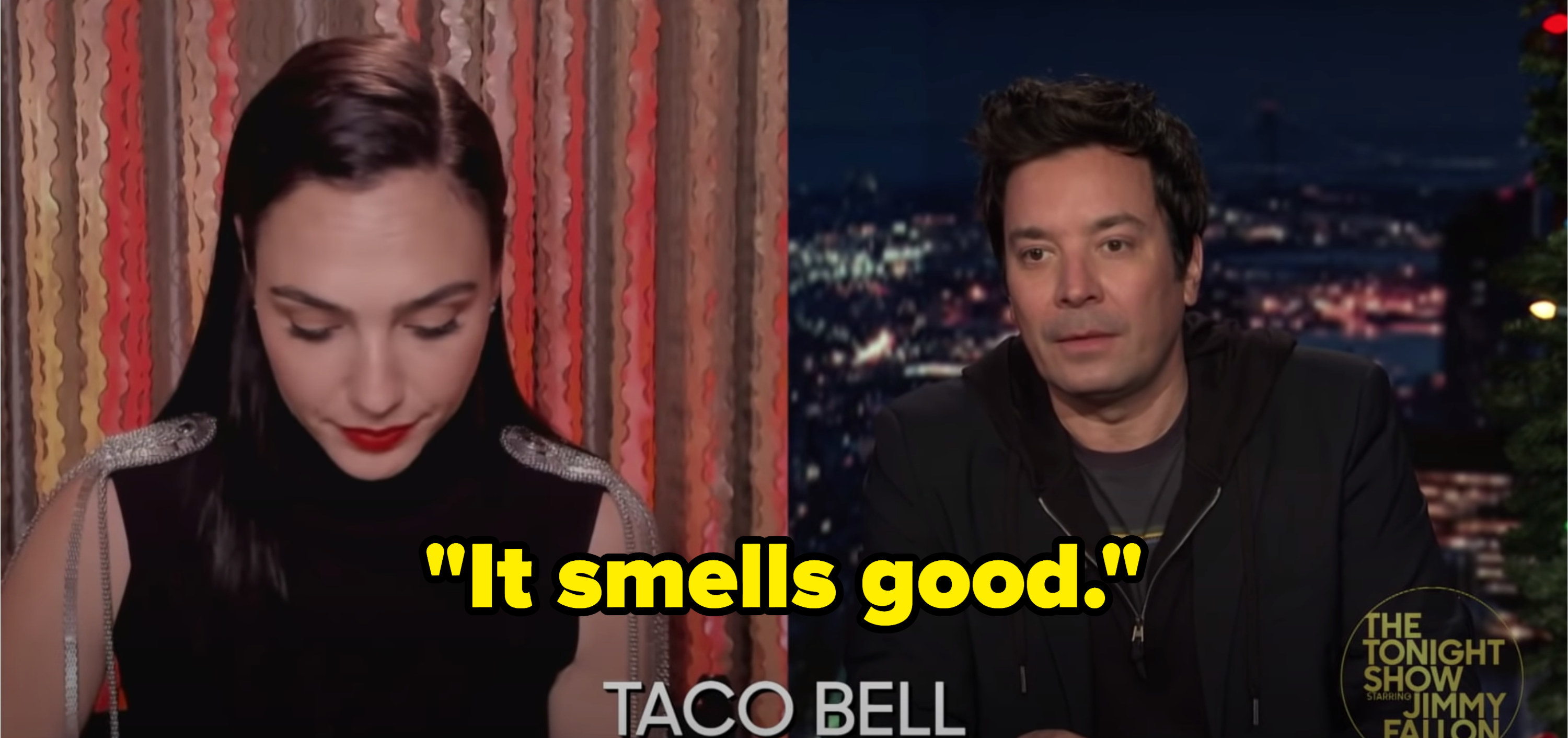 Gal Gadot next to Jimmy Fallon as she unwraps the taco and comments &quot;It smells good&quot;