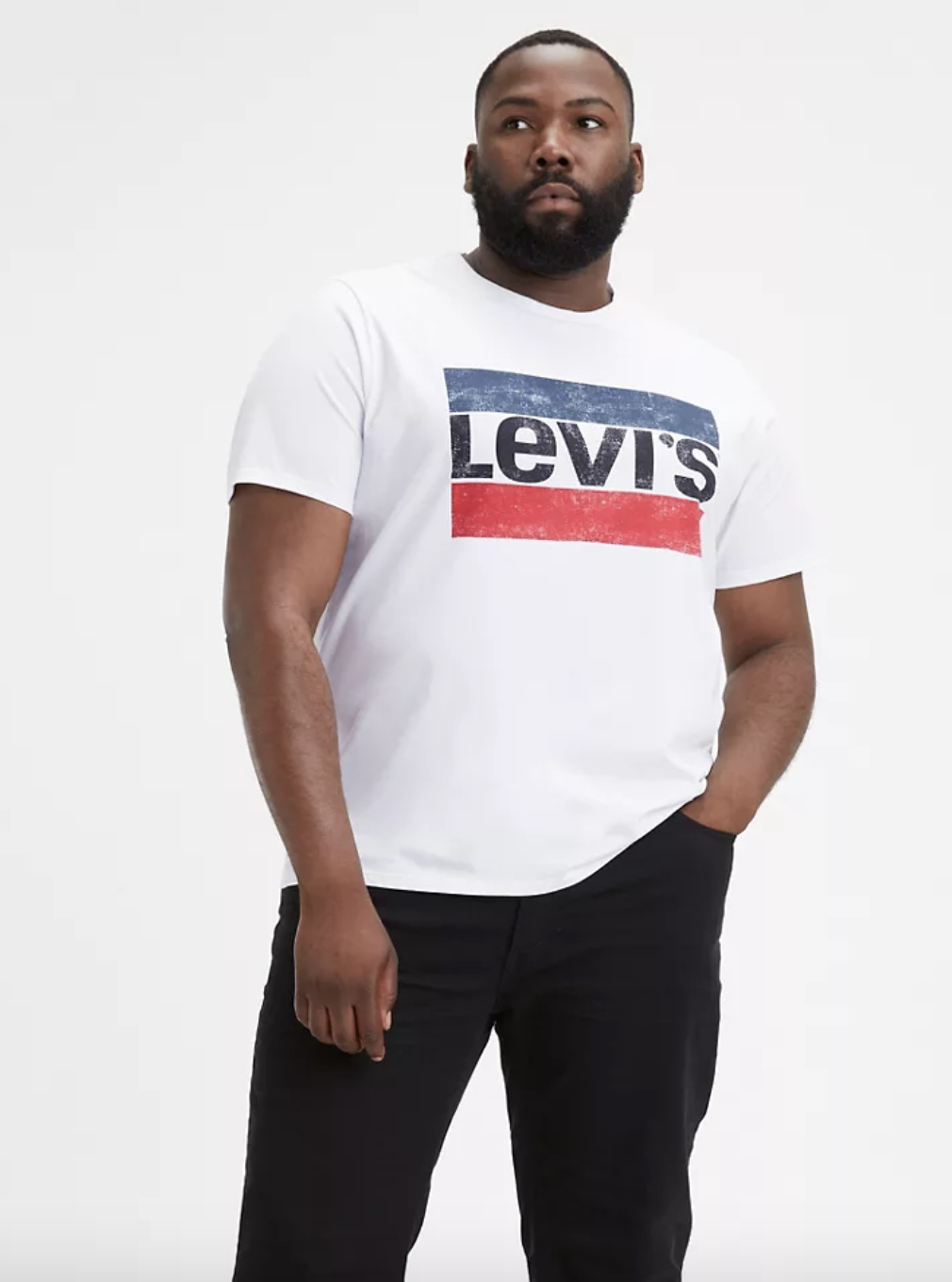 Model in a white t-shirt with a Levi&#x27;s graphic surrounded by red and blue bars in the middle of the chest 
