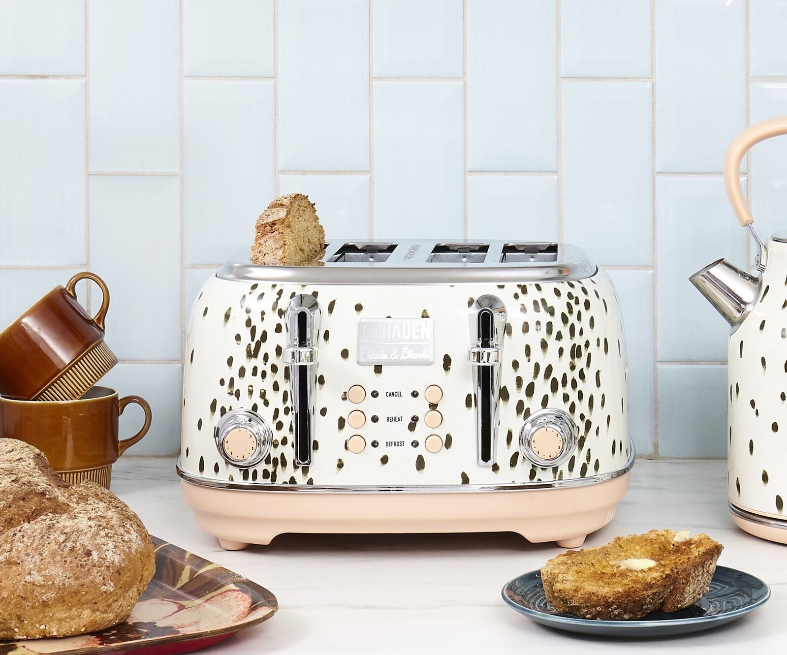 The four-slice toaster which has two dials, six buttons, and a black spotted finish