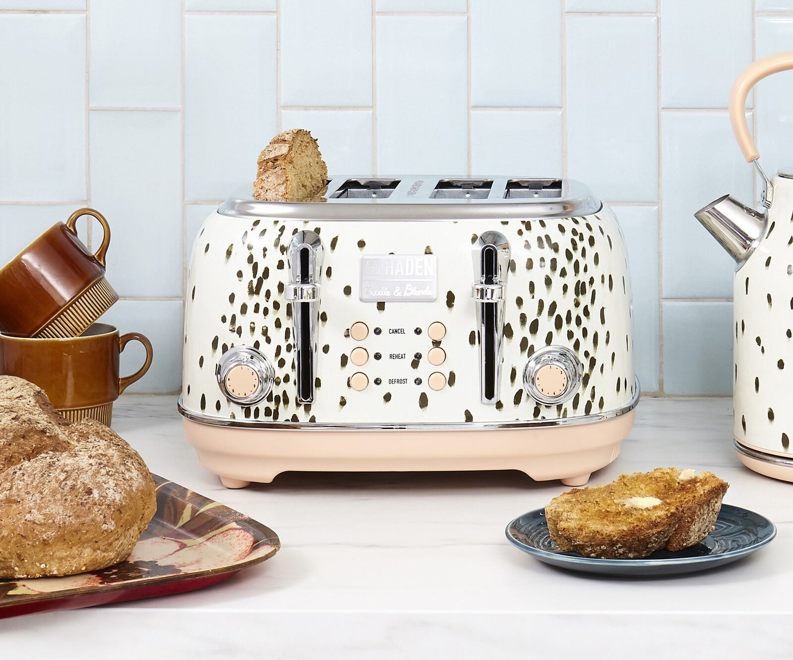 The four-slice toaster which has two dials, six buttons, and a black spotted finish