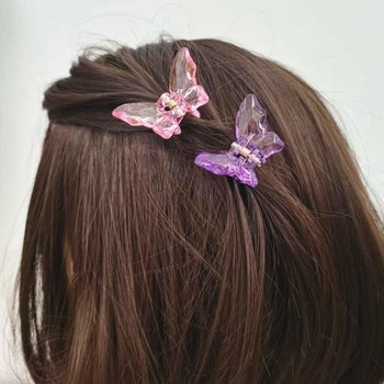 two plastic hair clips shaped like butterflies in hair