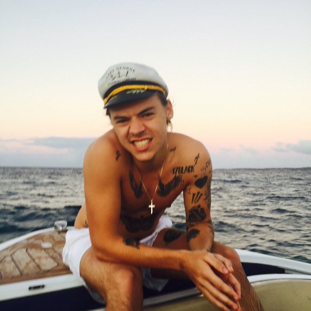Harry Styles shirtless on the water in a sailor hat