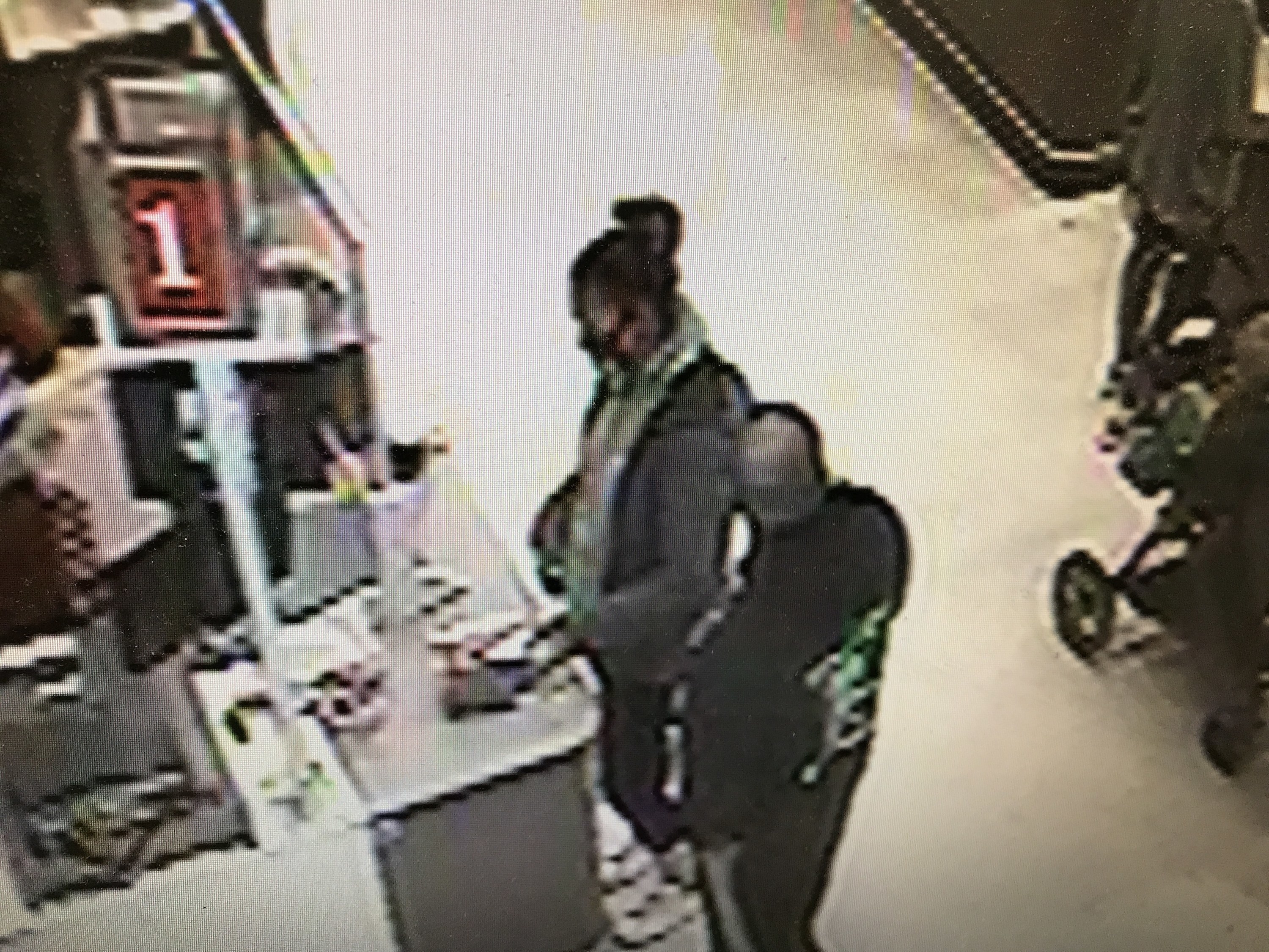 A security camera photo shows a man and woman standing close by at a checkout counter