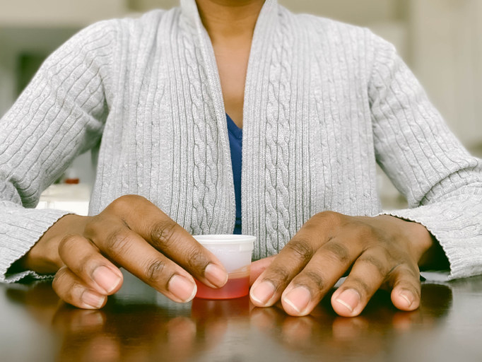 Image of hands holding cough medicine.