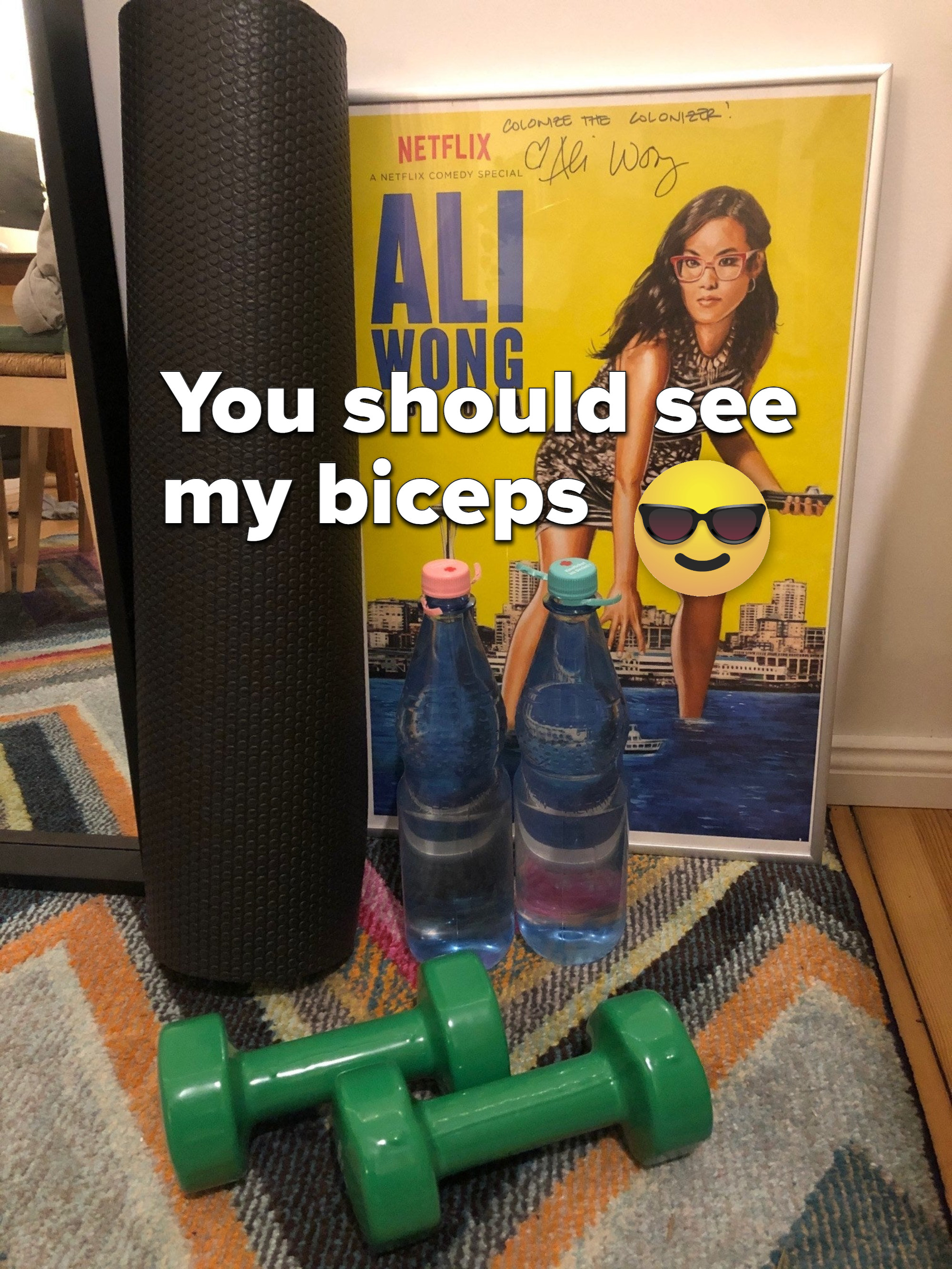 Photo of Michelle&#x27;s workout station, with a pair of dumbbells and two smaller filled-up water bottles doubling as lighter weights.