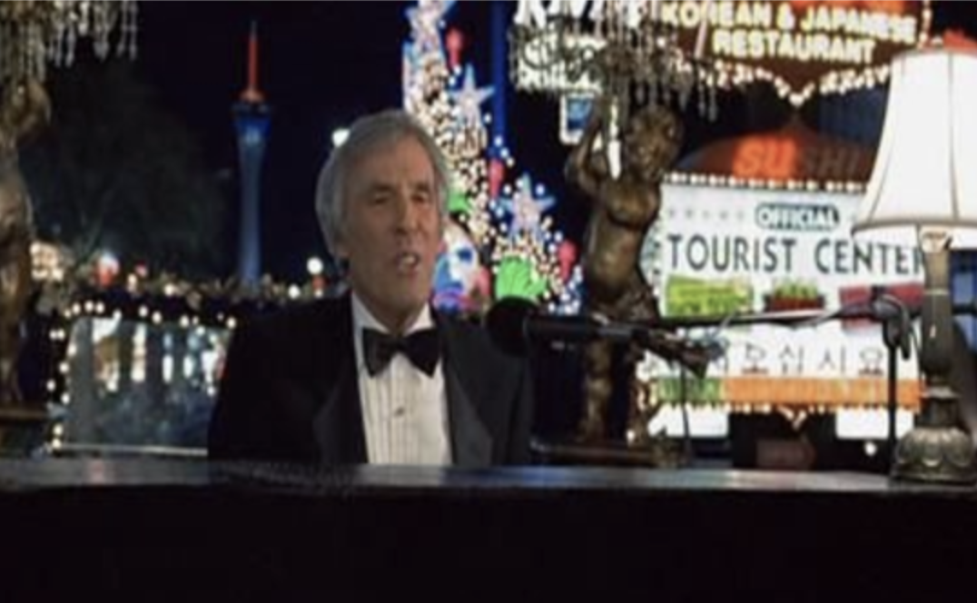 A tuxedoed Burt Bacharach playing a piano in Las Vegas