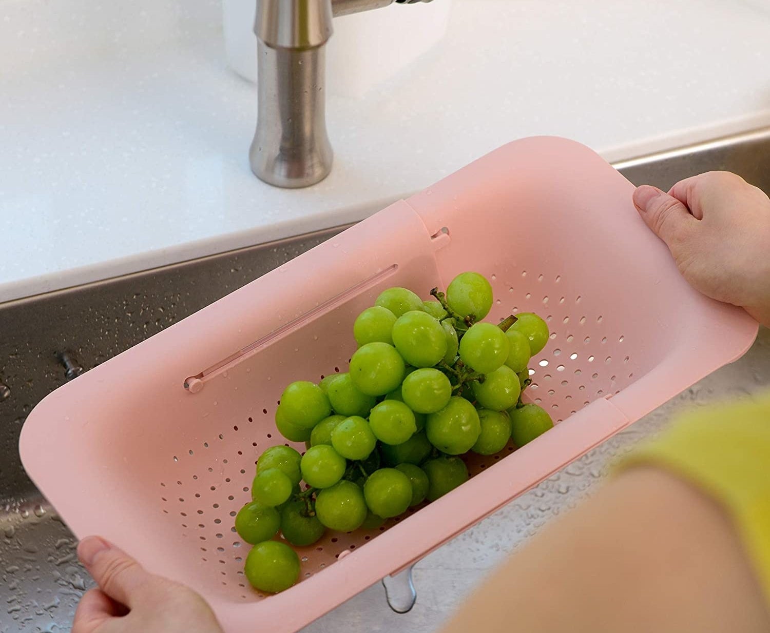 person drying grapes with the colander
