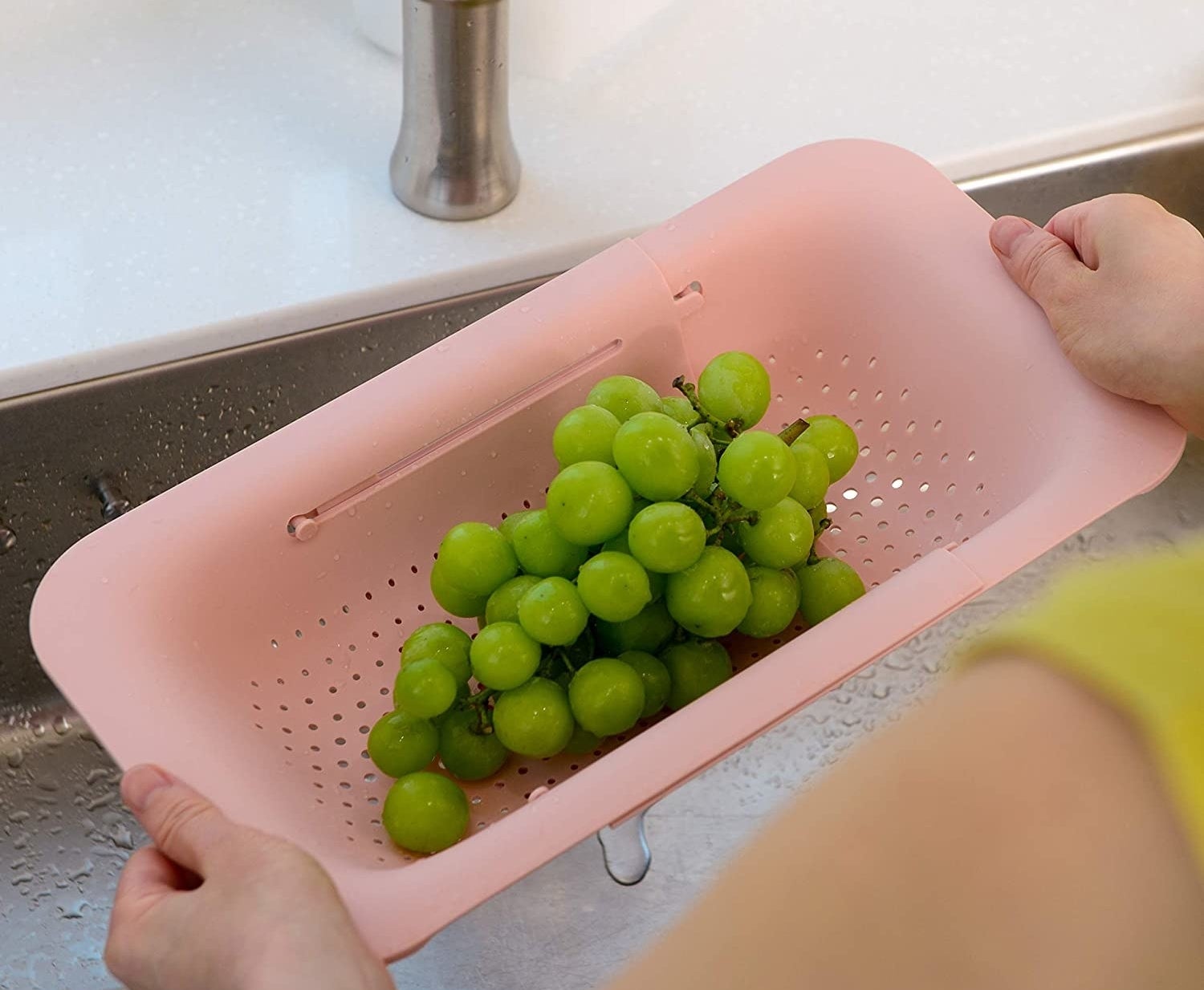 person drying grapes with the colander