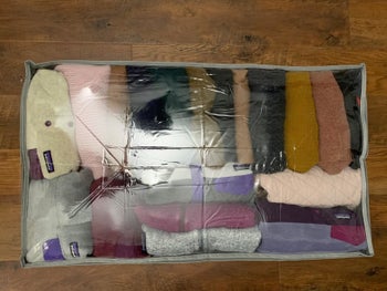 reviewer photo showing the underbed storage container neatly packed with sweaters and sweatshirts