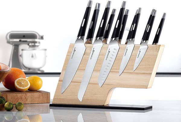 l-shaped wooden board with knives stuck to it 