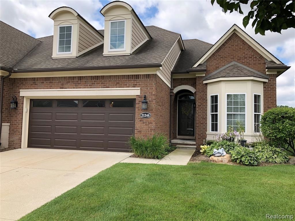 Brick house with garage on a manicured lawn