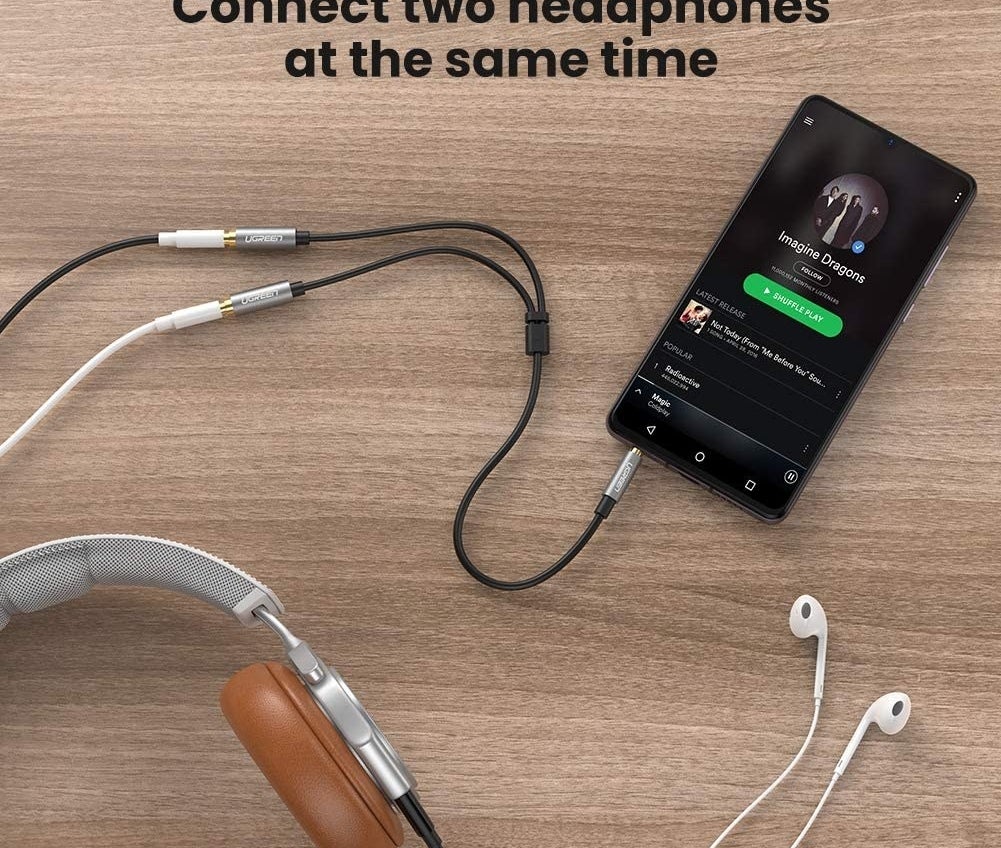 phone with the earphone splitter connected to a pair of headphones and a pair of earphones