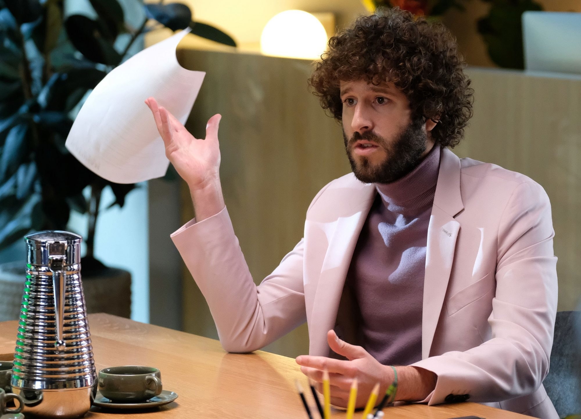 Lil Dicky in &quot;Dave&quot;; he is sitting in an office, talking to someone off-camera