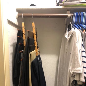 reviewer photo showing how the hanger collapses to take up a fraction of the space while still holding 5 pairs of pants 