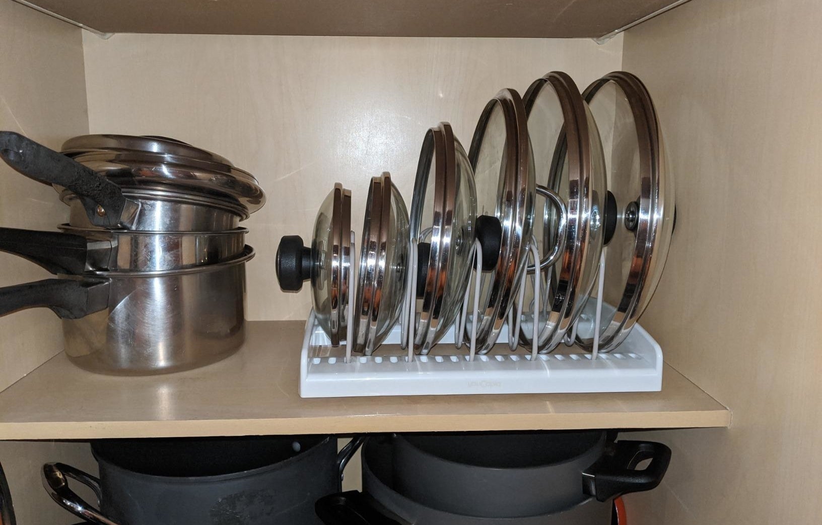 reviewer photo showing lids to pots and pans neatly organized in the bakeware rack