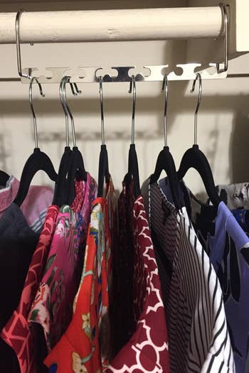 reviewer photo showing seven shirts hanging on their closet rack 