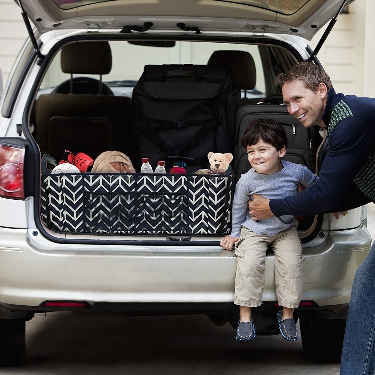 person holding child sitting on trunk with the trunk organizer