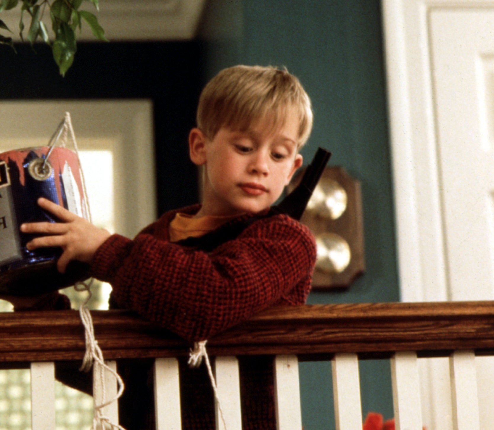 Macaulay Culkin as Kevin McCallister ready to dump a can of paint on his victims