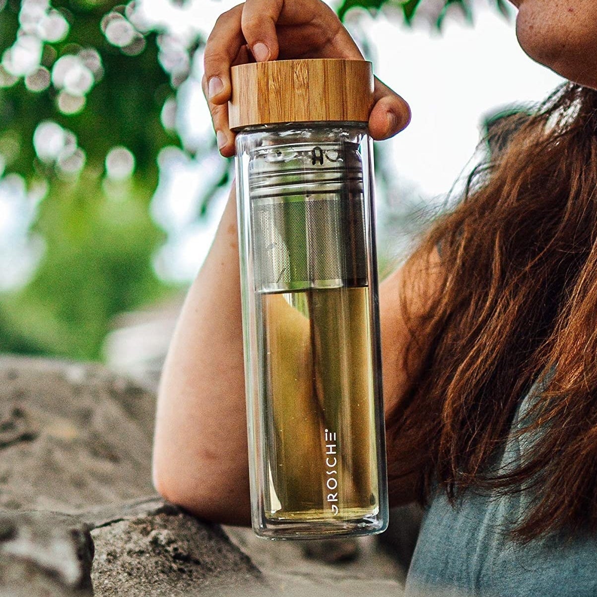A person holding the glass tumbler