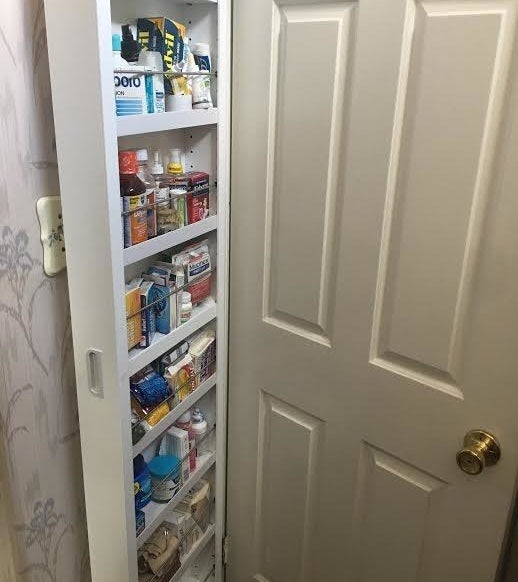 same reviewer showing the door cabinet completely stocked with extra toiletries 