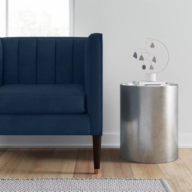 The round silver table next to a couch