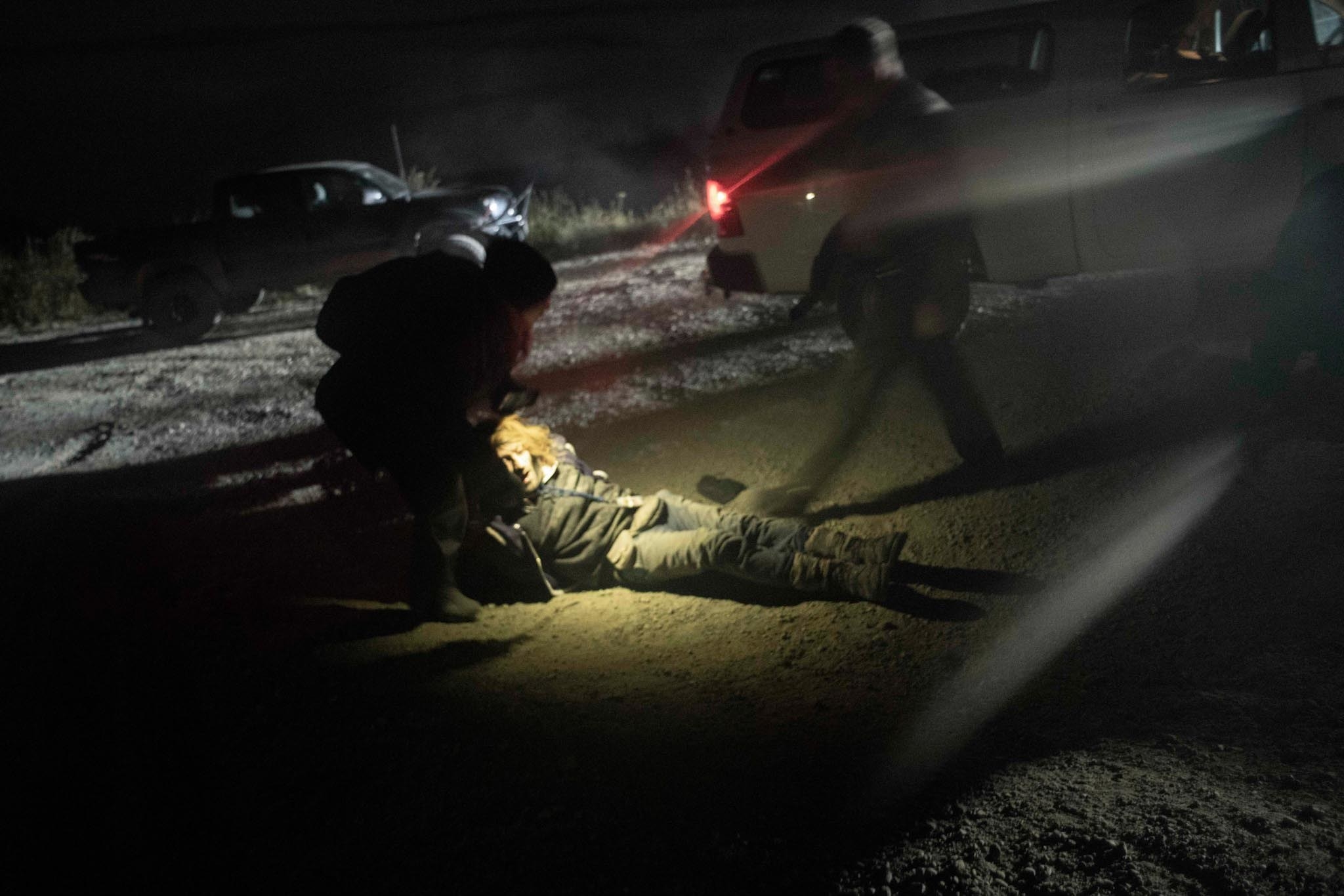 An activist is dragged on the ground by another activist as the cops approach 