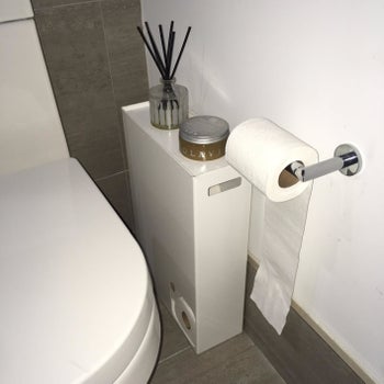 reviewer photo showing toilet paper stocker in their bathroom with a candle on it