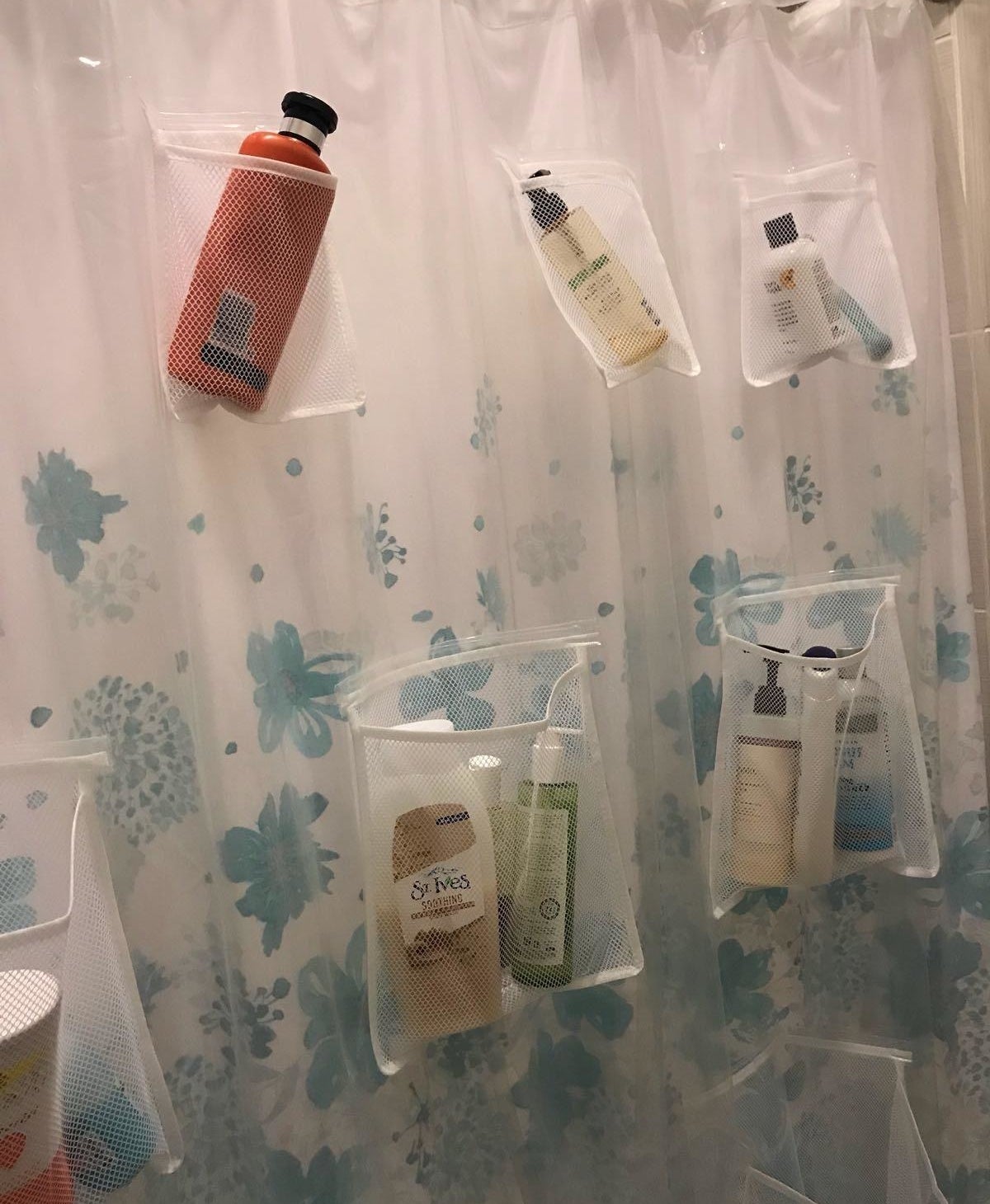 reviewer photo showing the shower curtain with bath products in the pockets 