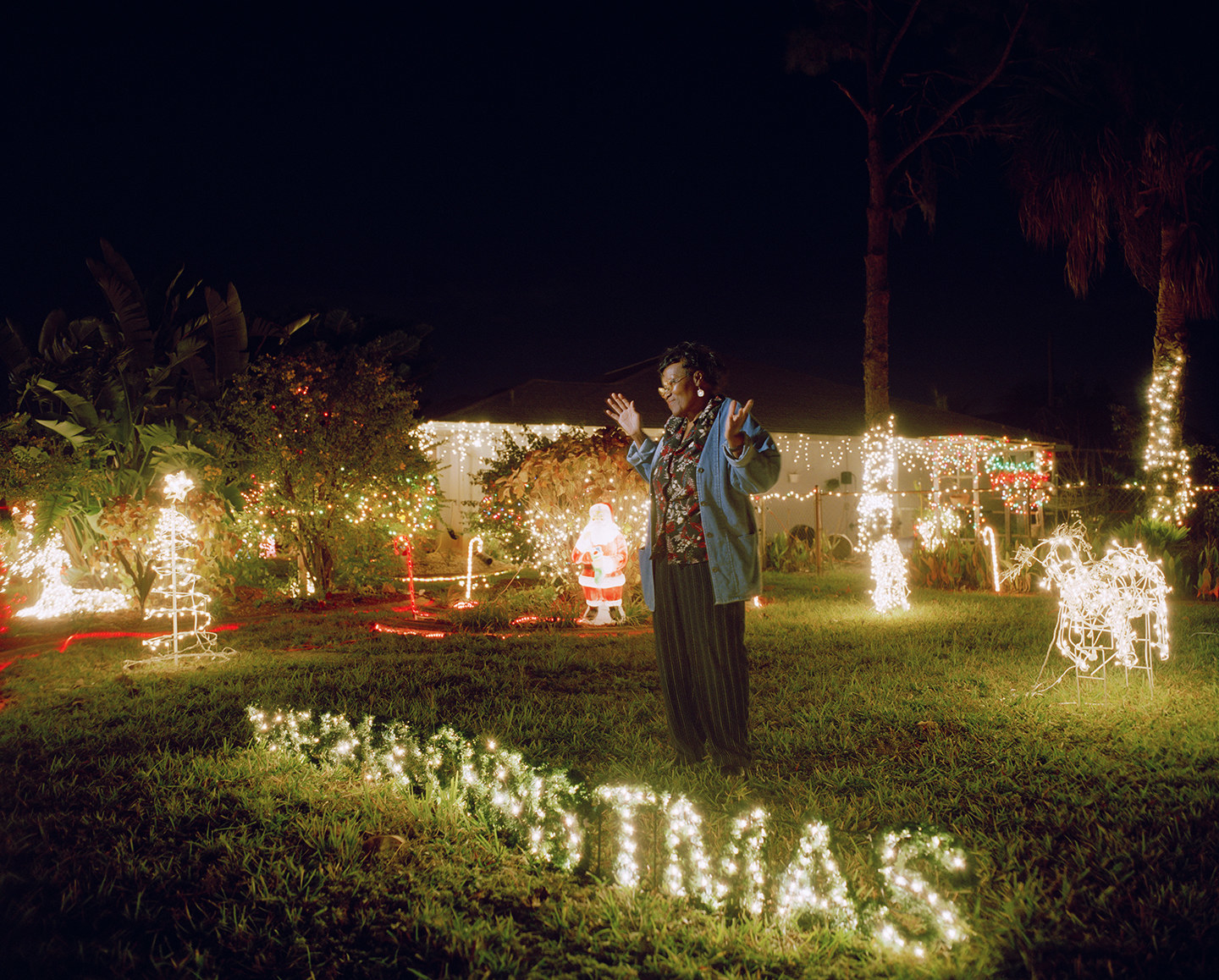 A woman on her lawn surrounded by Christmas ornaments