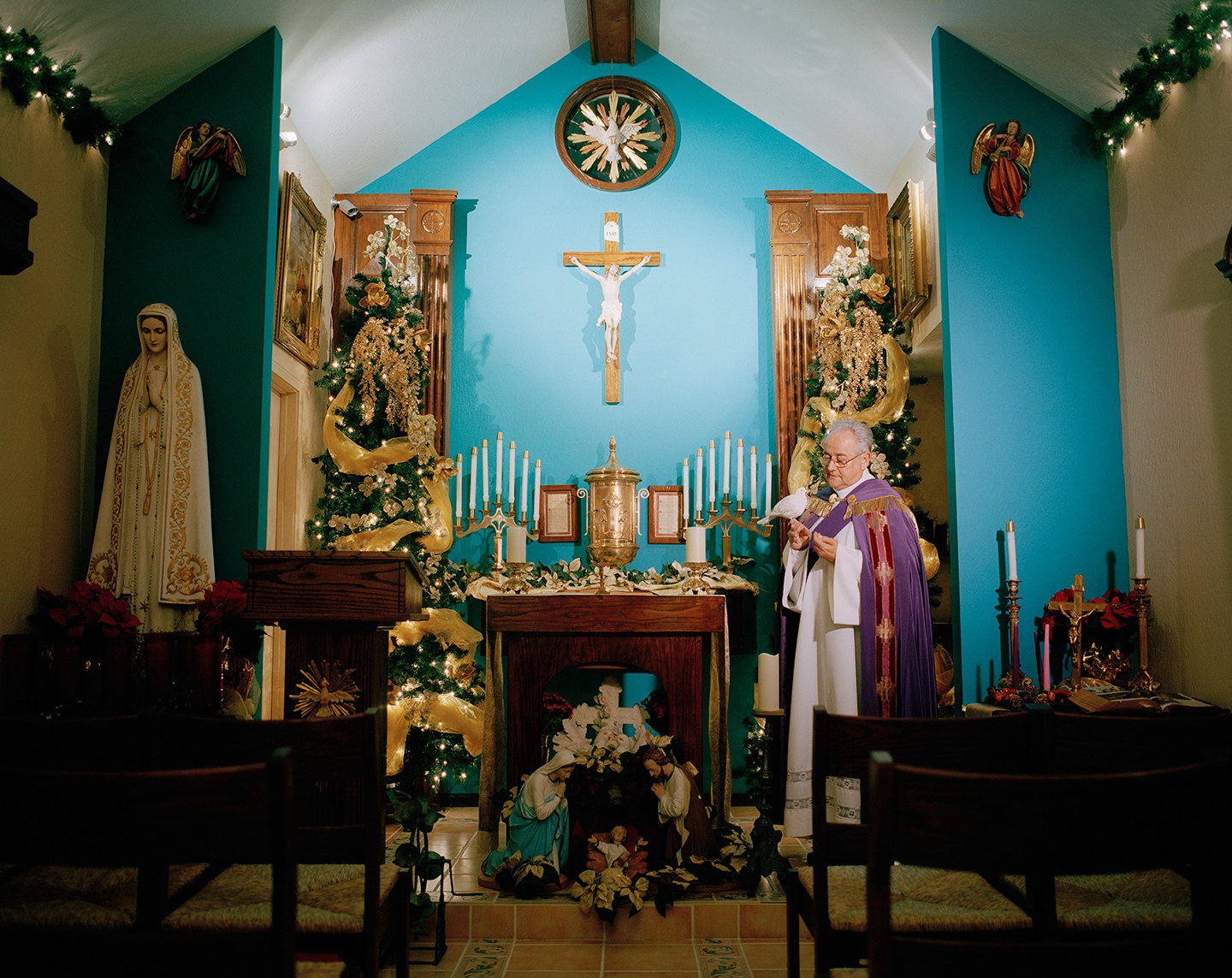 A man dressed as a priest in a small shrine inside a home