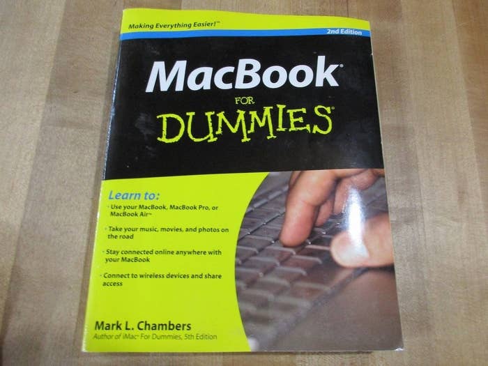 A &quot;MacBook for Dummies&quot; book featuring a hand typing on a keyboard on the cover