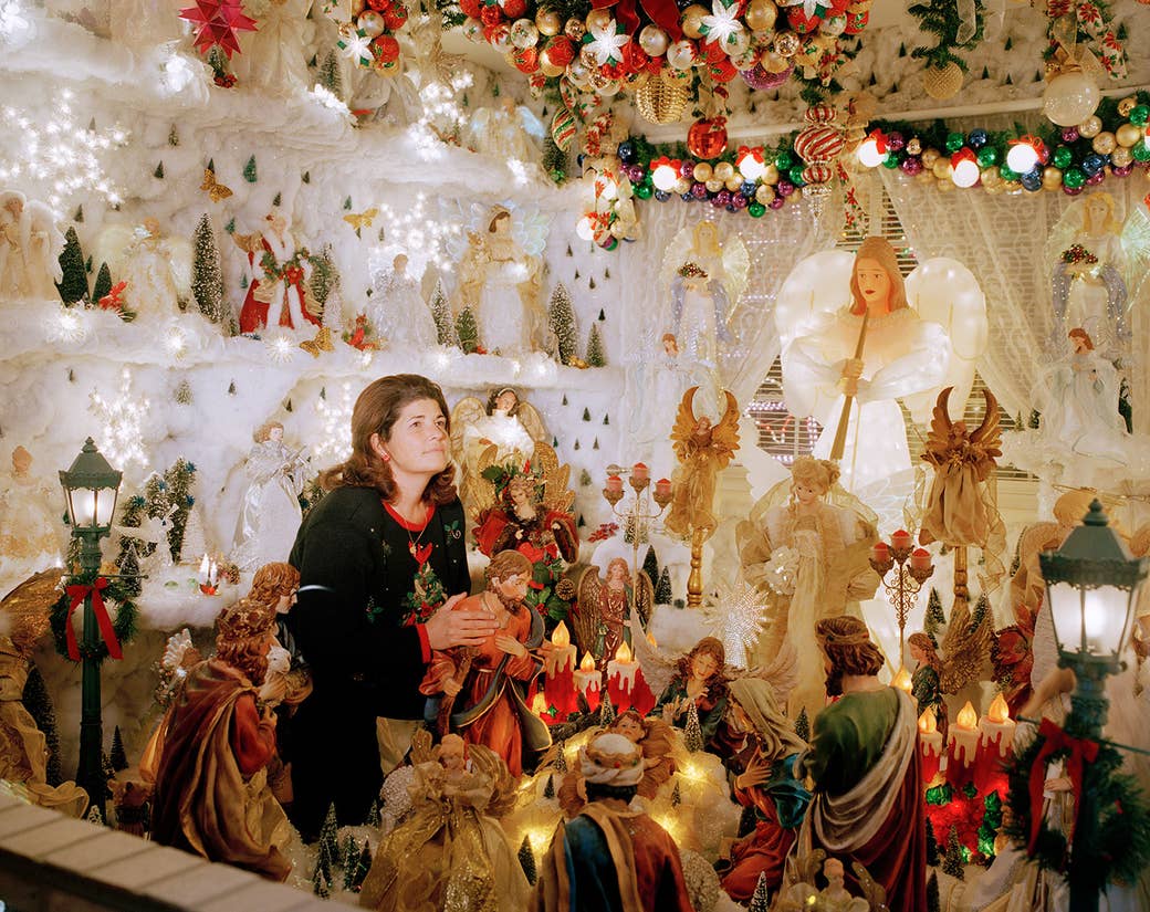 A woman sitting in a large nativity display indoors