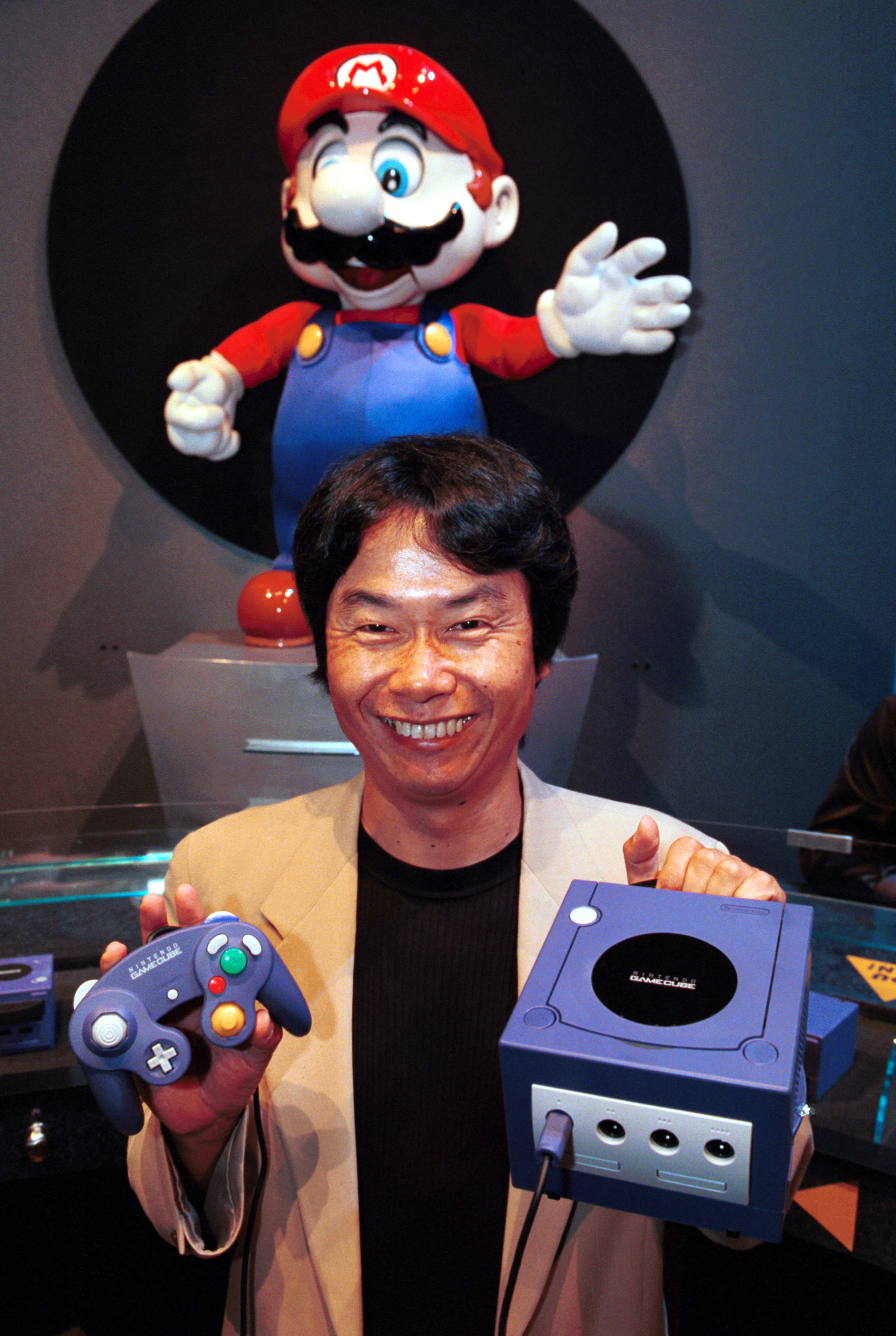 Shigeru Miyamoto, founder of Nintendo Mario, holding a Gamecube console and controller 