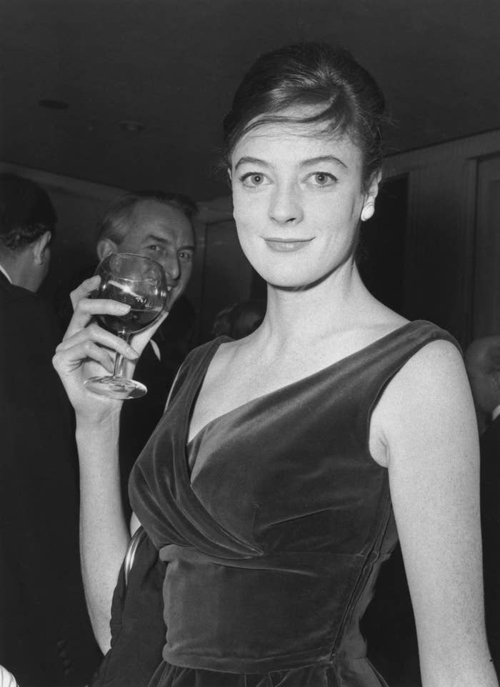 Maggie in a velvet dress holding a glass of wine