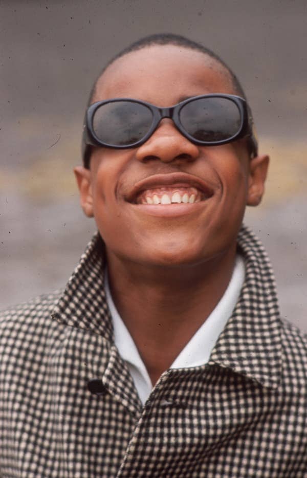 Steve smiling wearing cat-style sunglasses and a houndstooth coat