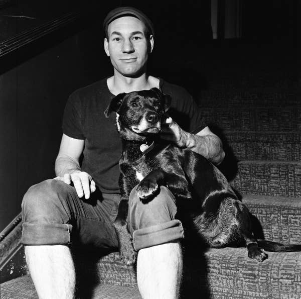 Patrick sitting on some stairs with a black dog on his lap