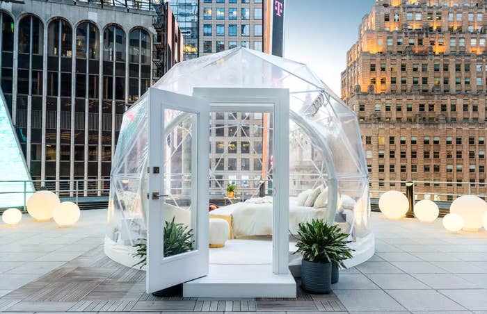 A clear dome with a bed on a NYC rooftop  