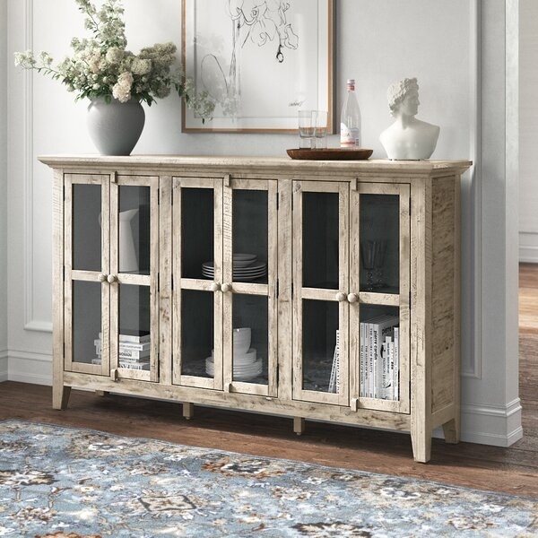 The sideboard in gray, with two levels of shelves and three sets of glass-fronted double doors