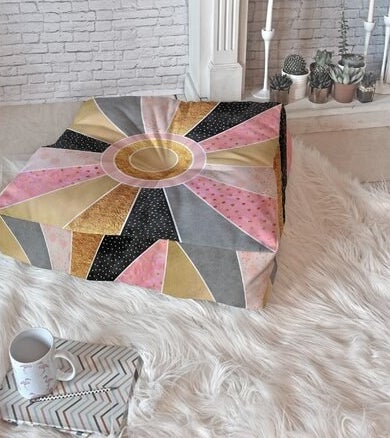 The pillow, which is large, square, and has a patchwork pattern