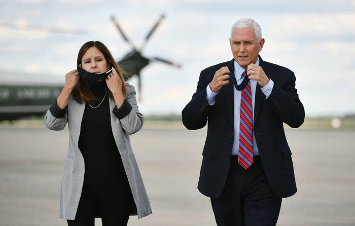 Mike Pence and his Karen Pence take their face masks off while walking on a plane tarmac