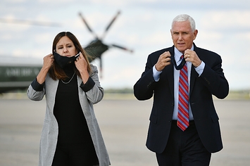 Mike Pence and his Karen Pence take their face masks off while walking on a plane tarmac