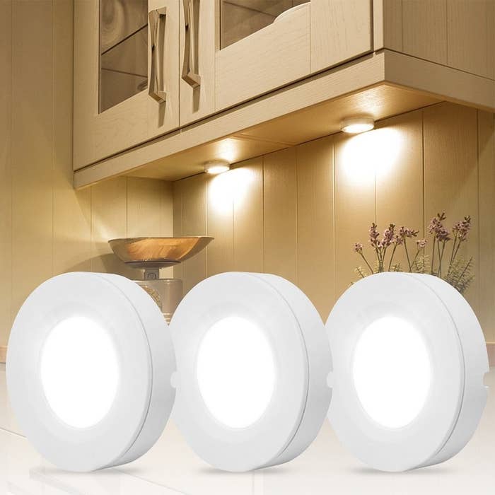 three led lights on display in front of a cabinet that has LED lights adhered under it