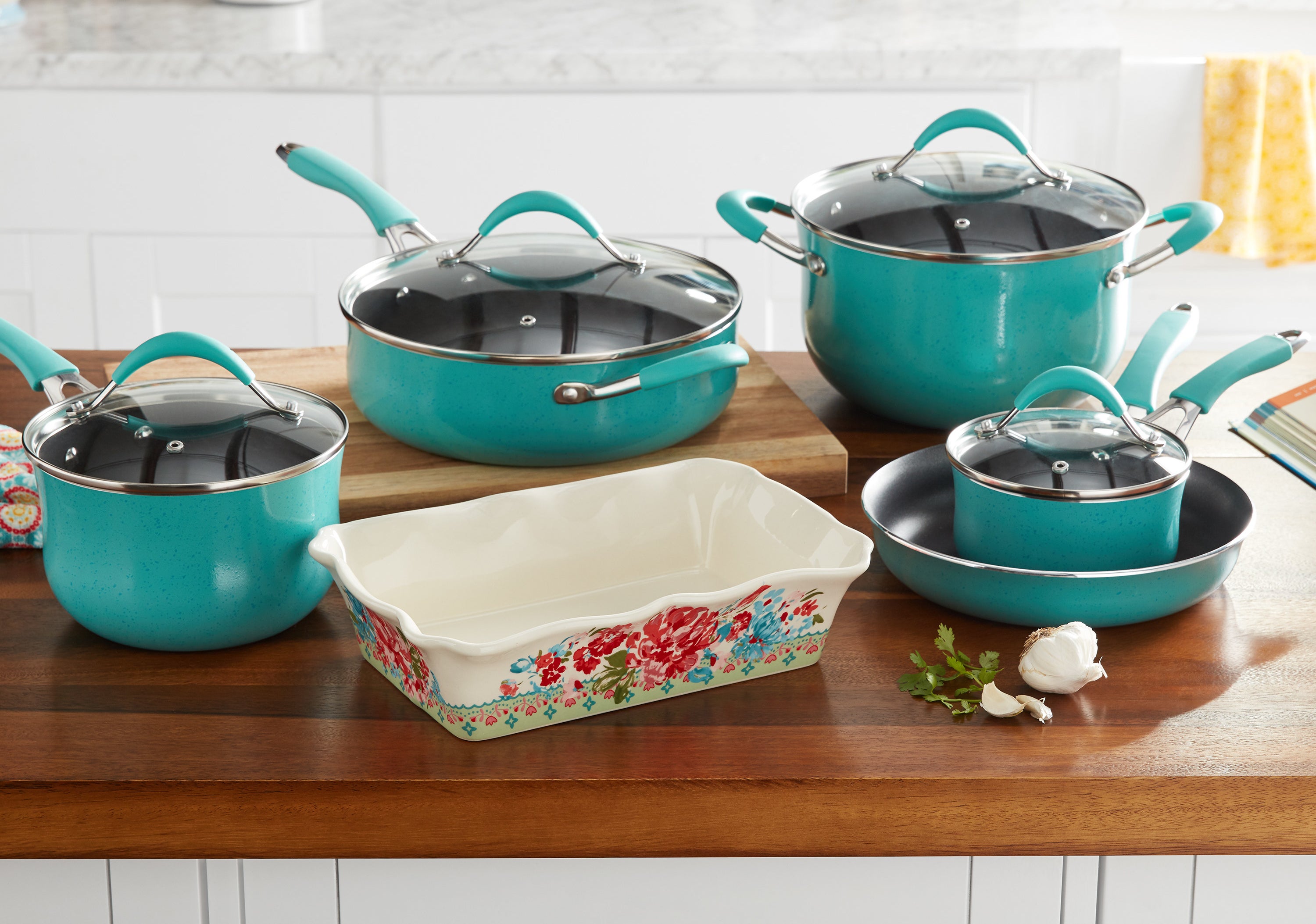 turquoise pots and pans and a floral casserole dish on the kitchen counter