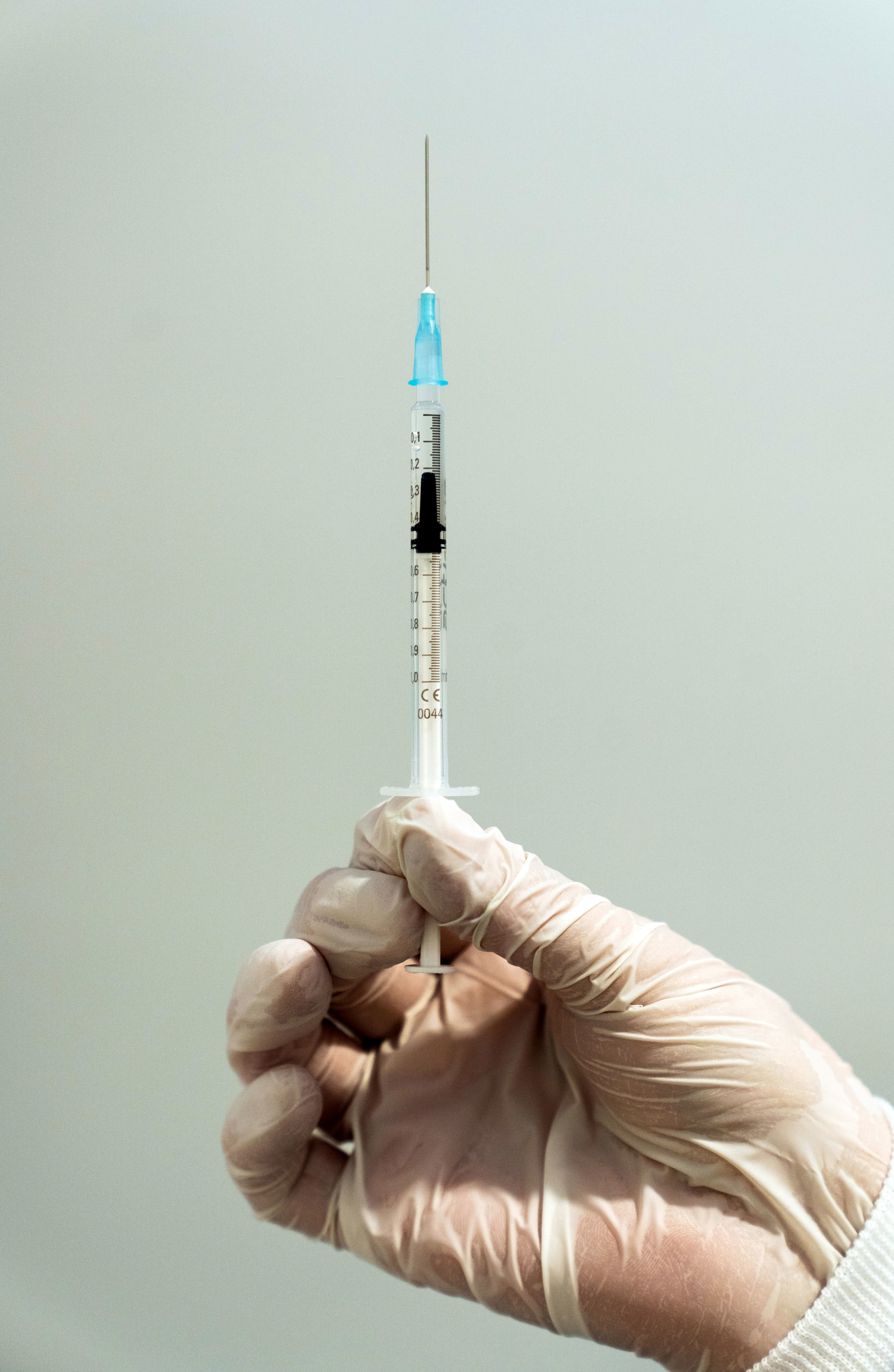 A healthcare worker holds a syringe