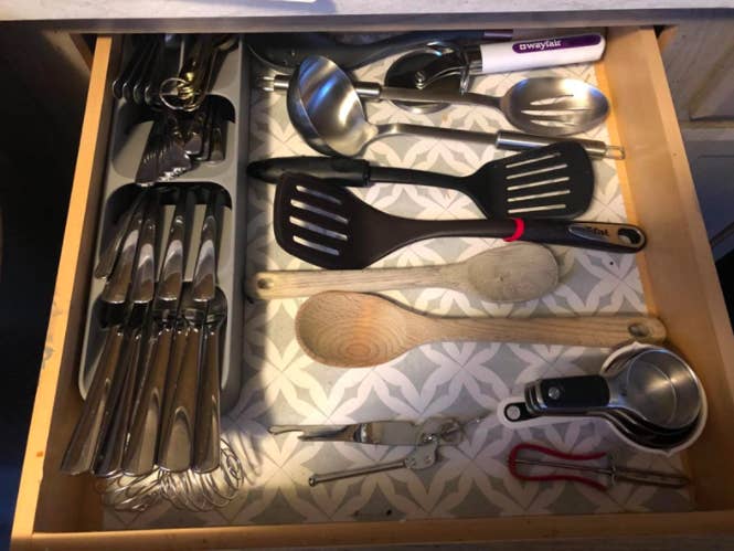 reviewer photo showing silverware organizer on the left of a drawer with plenty of room for other utensils on the right
